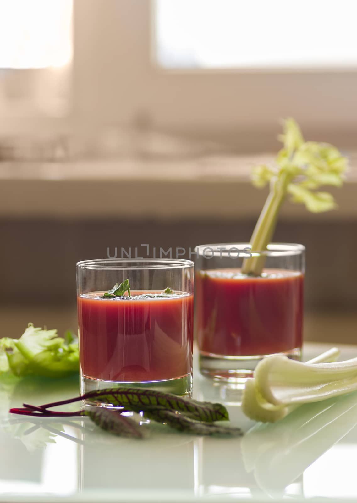 still life with tomato juice in glass glasses with greens