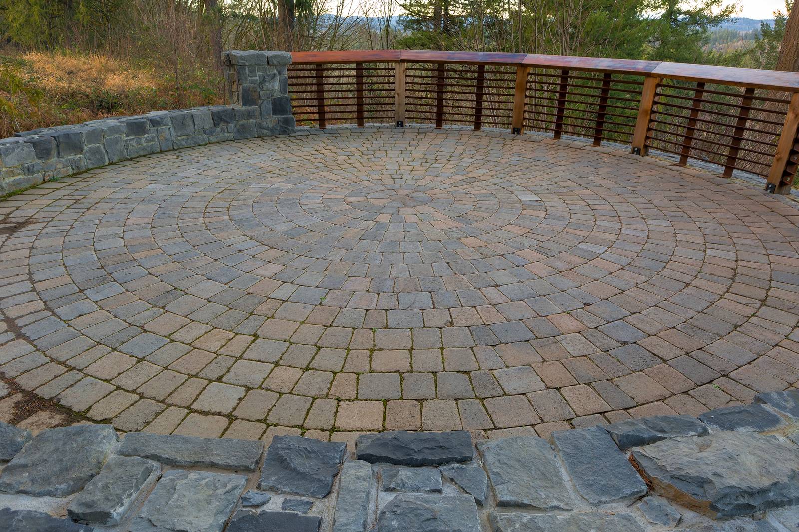 Garden Backyard circular brick stone pavers hardscape patio with wood railings stone wall landscaping
