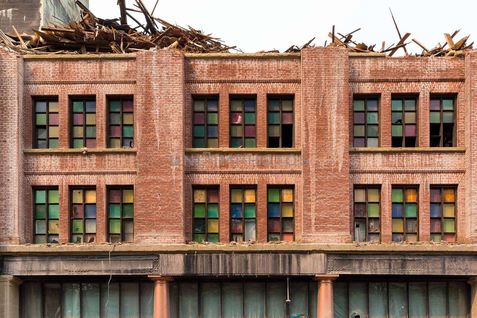 Front facade with stained glass windows of old brick building in downtown Portland Oregon being demolished