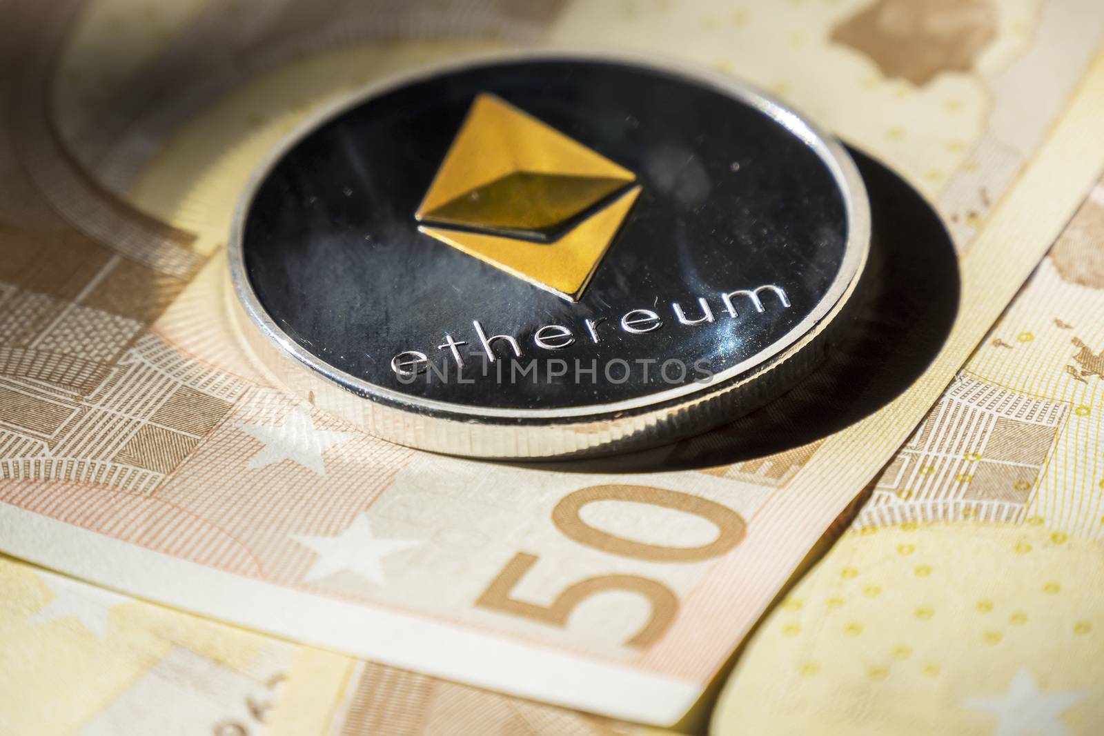 Cryptocurrency coins over euro banknotes; Ethereum coin by max8xam