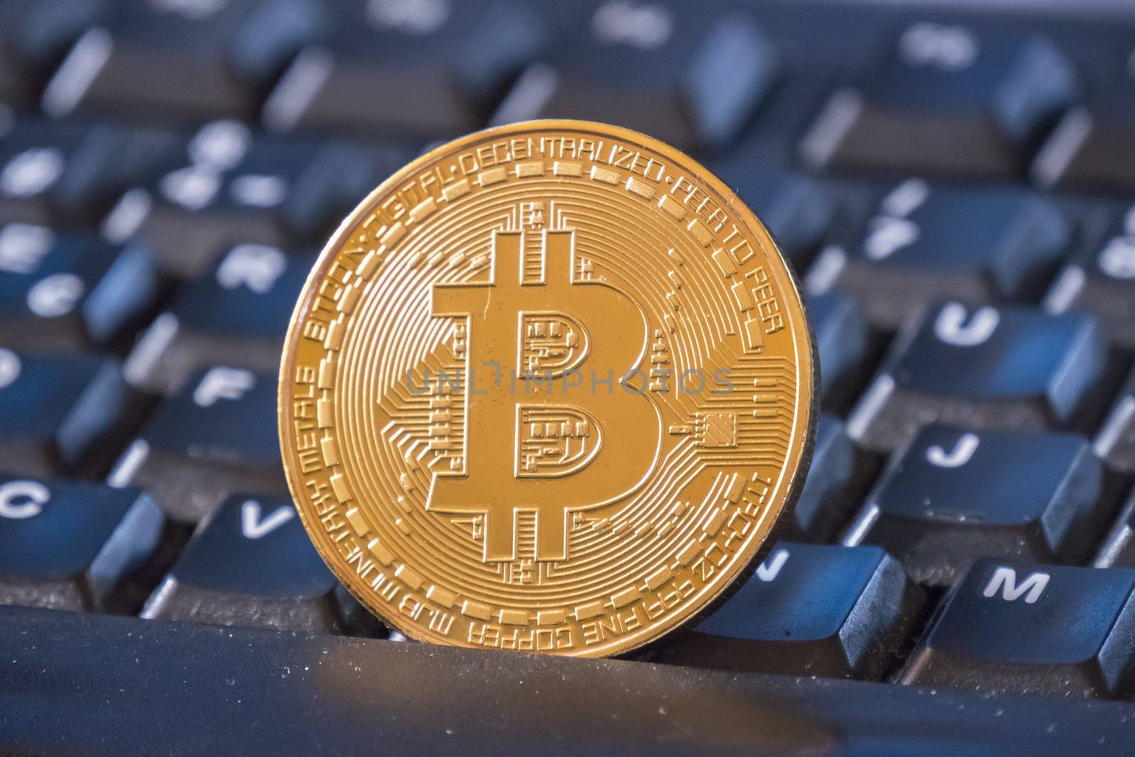 Bitcoin coin over black keyboard
