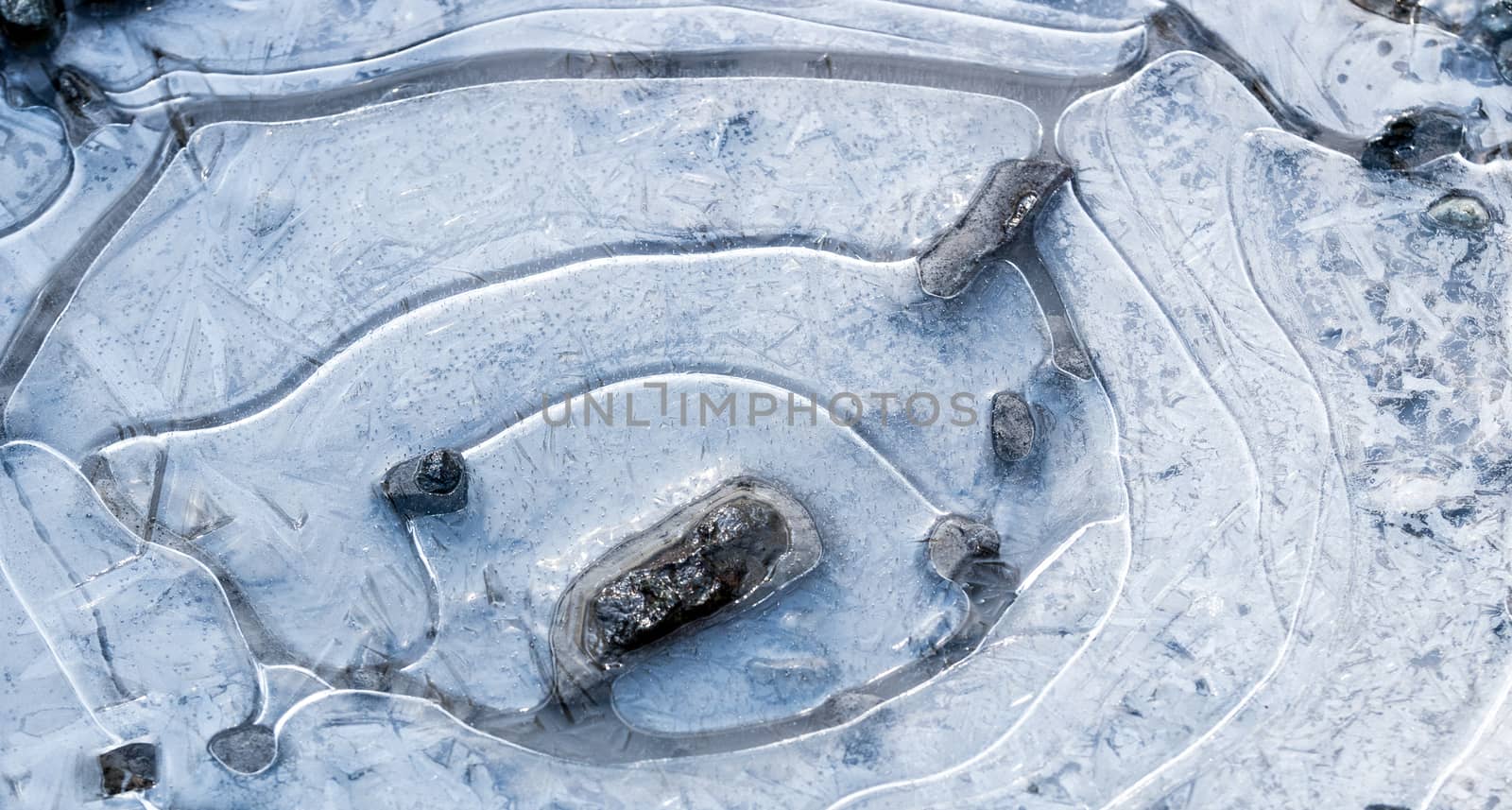 Mud puddle frozen over with white ice crystals by experiencesnw