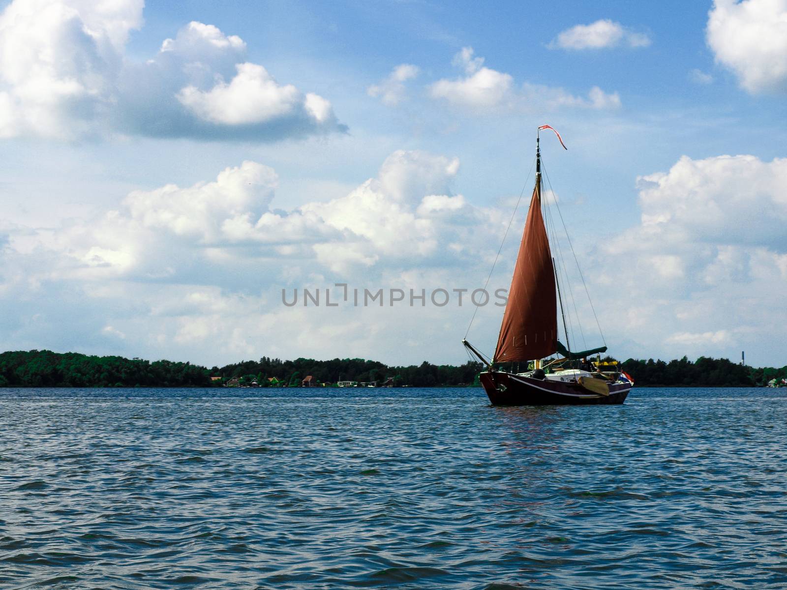 Sailing yacht with red sail near Groningen, Netherlands by kimbo-bo