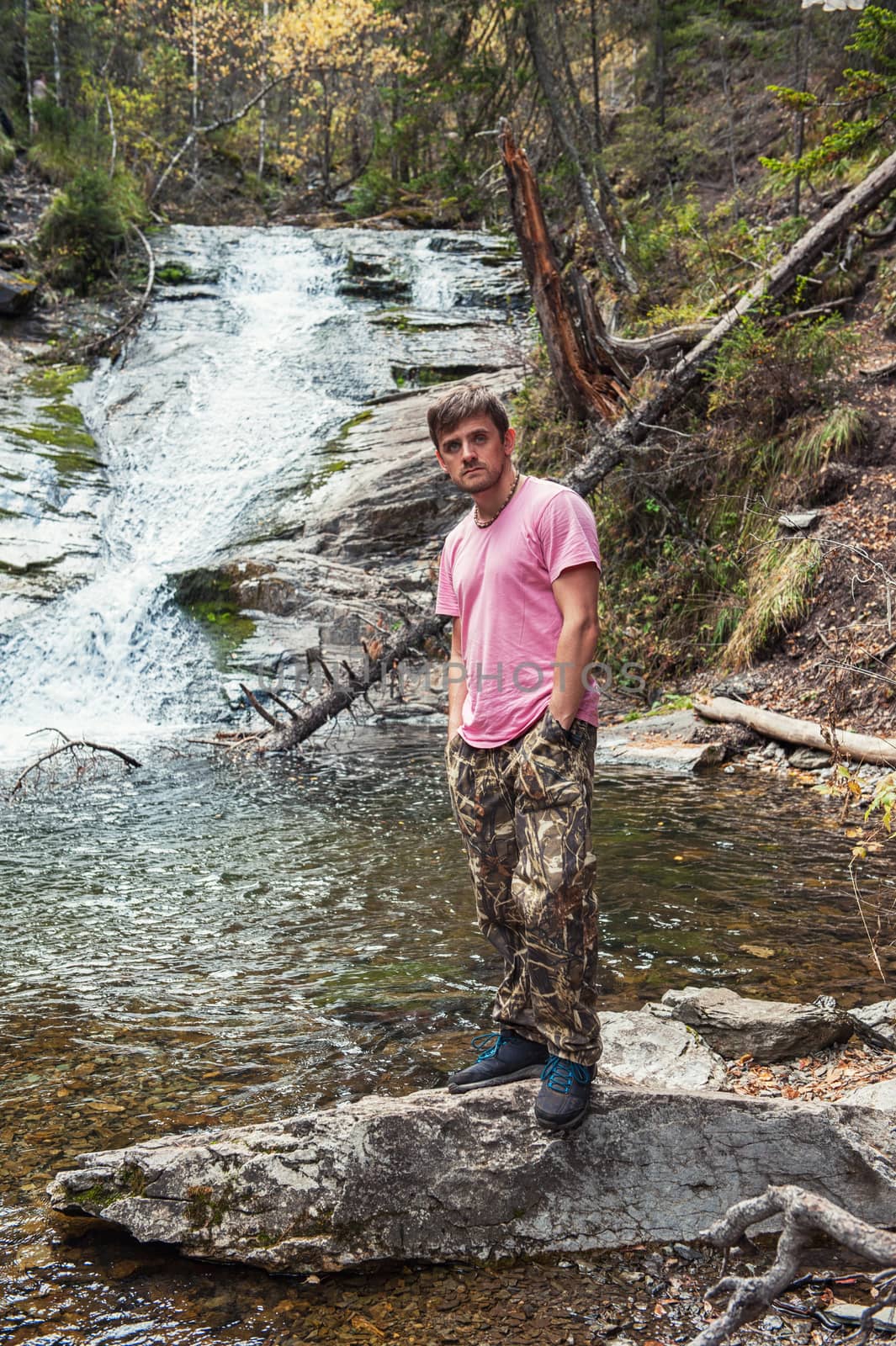 Man standing in front of waterfall in Altai mountains