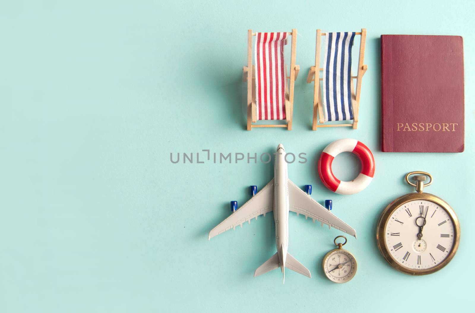 Travel assessories including miniature sun deck chair, airplane, clock and passport with space