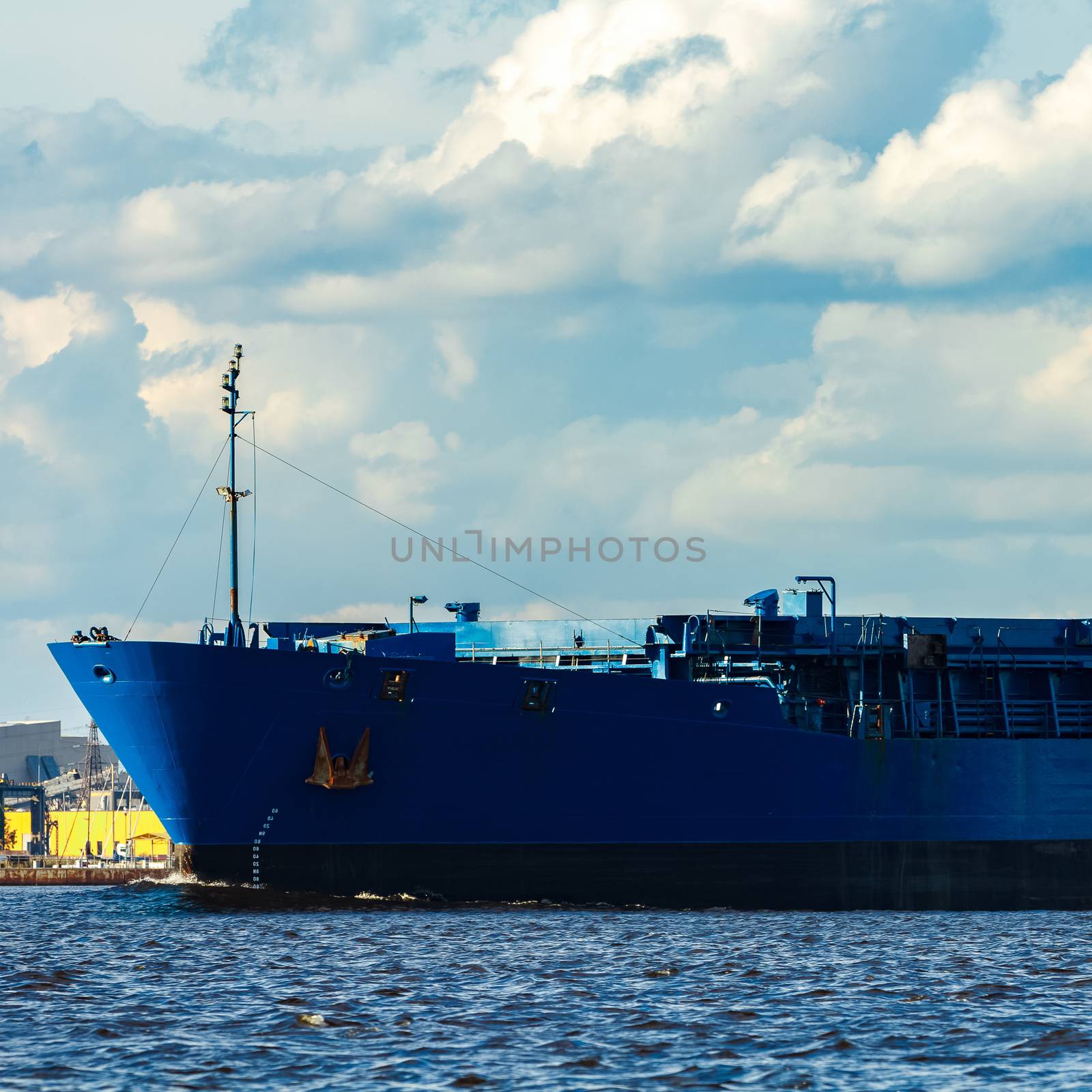 Merchandise import. Large blue cargo ship moving to Riga port