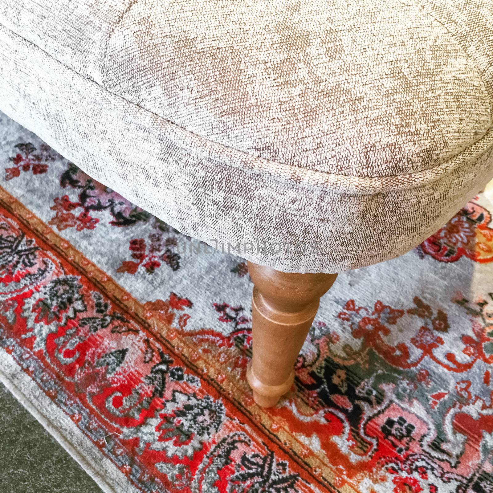 Detail of a luxurious armchair on a classic rug by anikasalsera