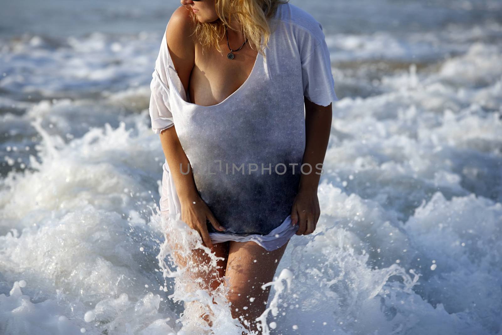 Woman in a wet dress at coast of the sea