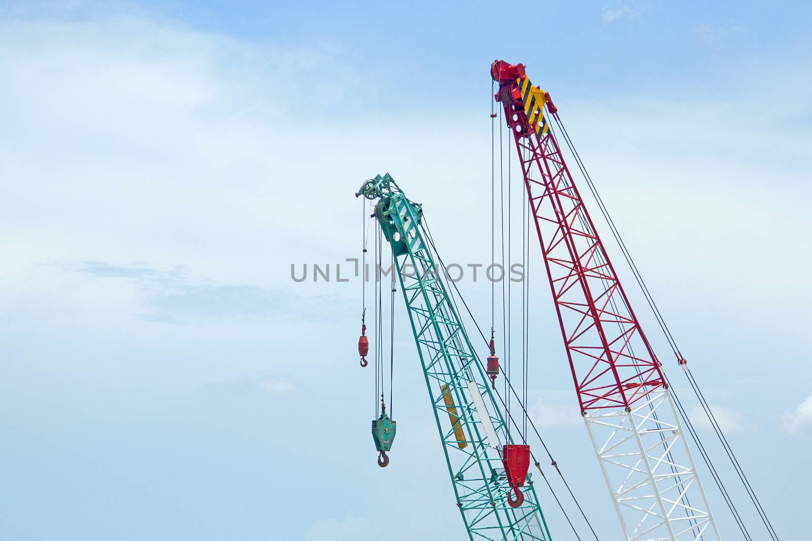 Crane lift green and red In the blue sky by TakerWalker