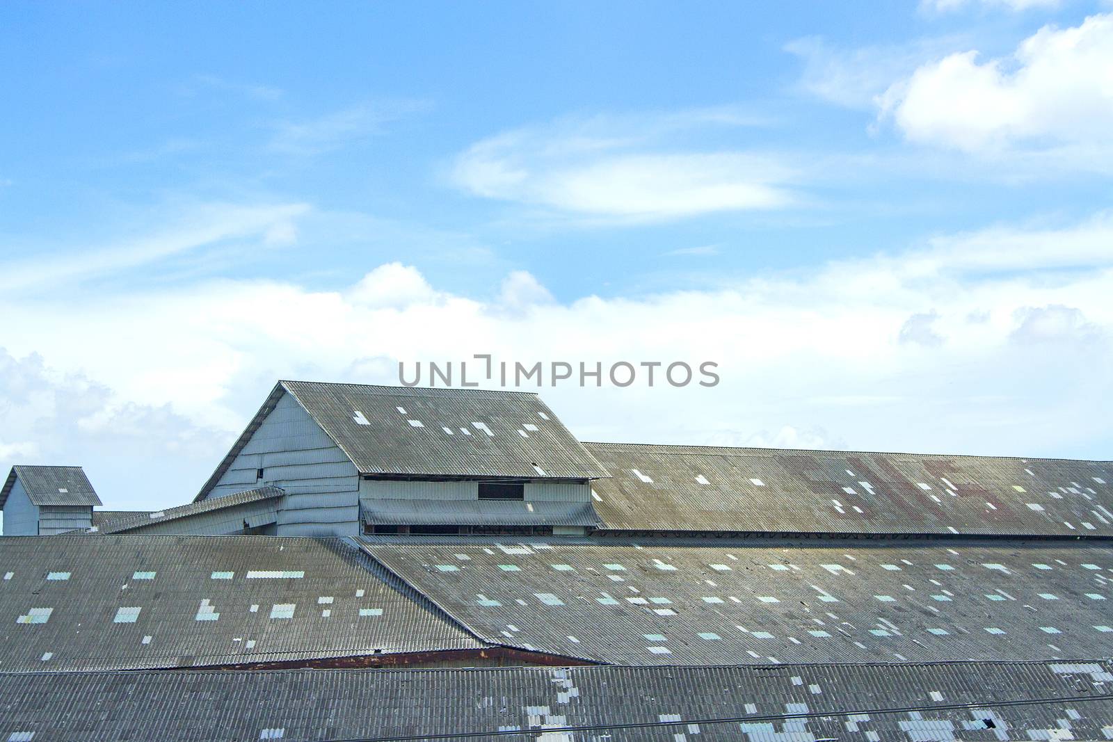 The roof of an old warehouse in the blue sky.