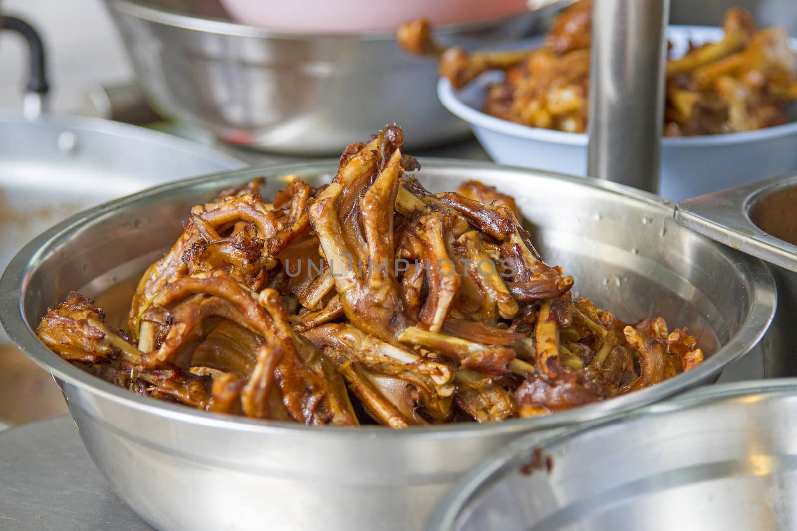 Fried duck feet in a silver container.