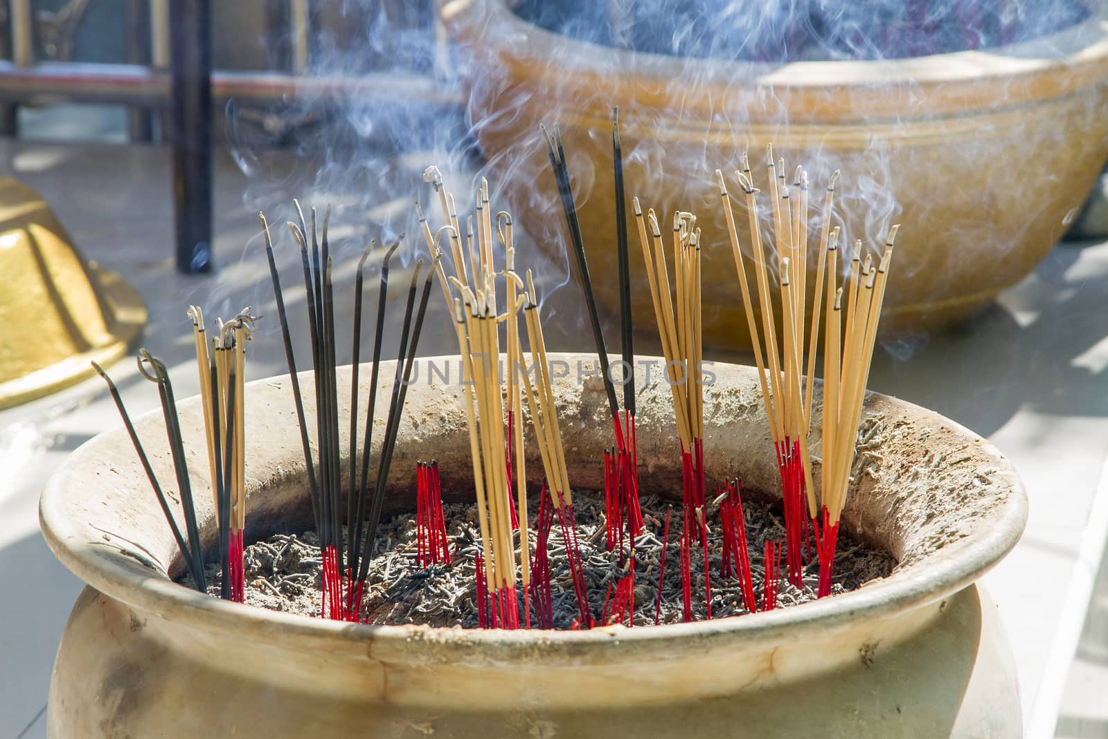 Incense burner with orange incense and black smoke.
