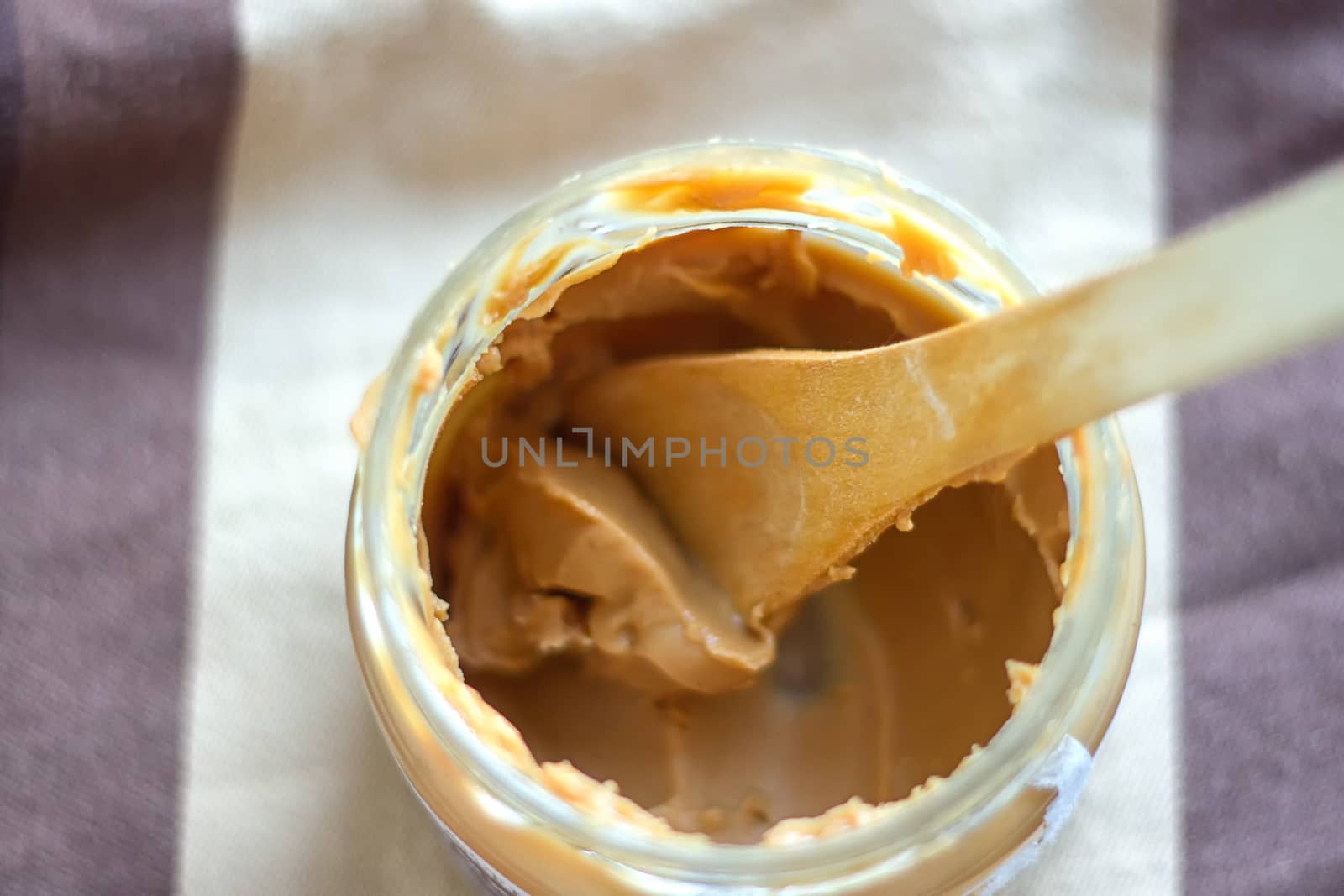 an open jar of peanut butter with spoon