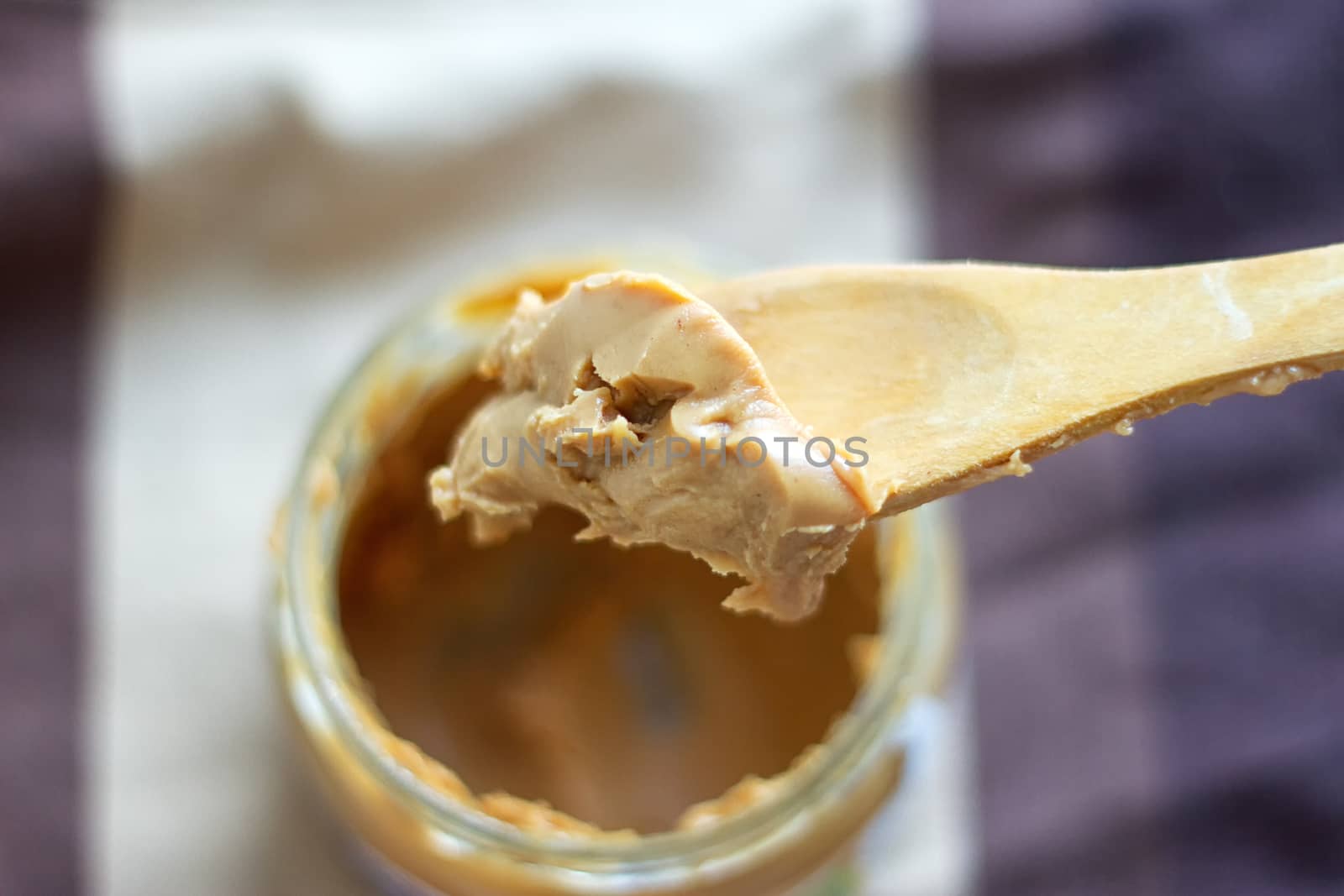 an open jar of peanut butter with spoon