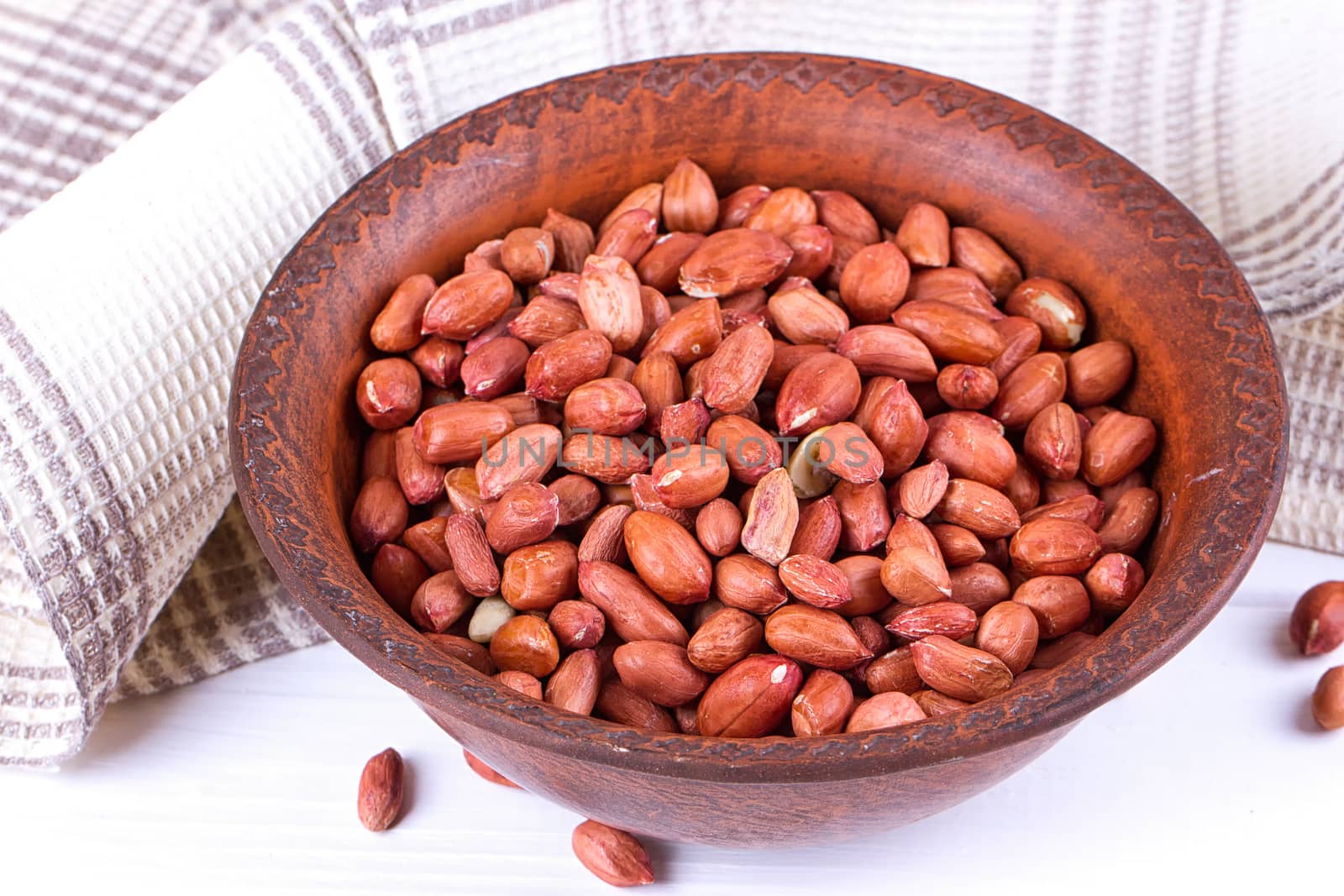 Peanuts in a brown plate. on white background