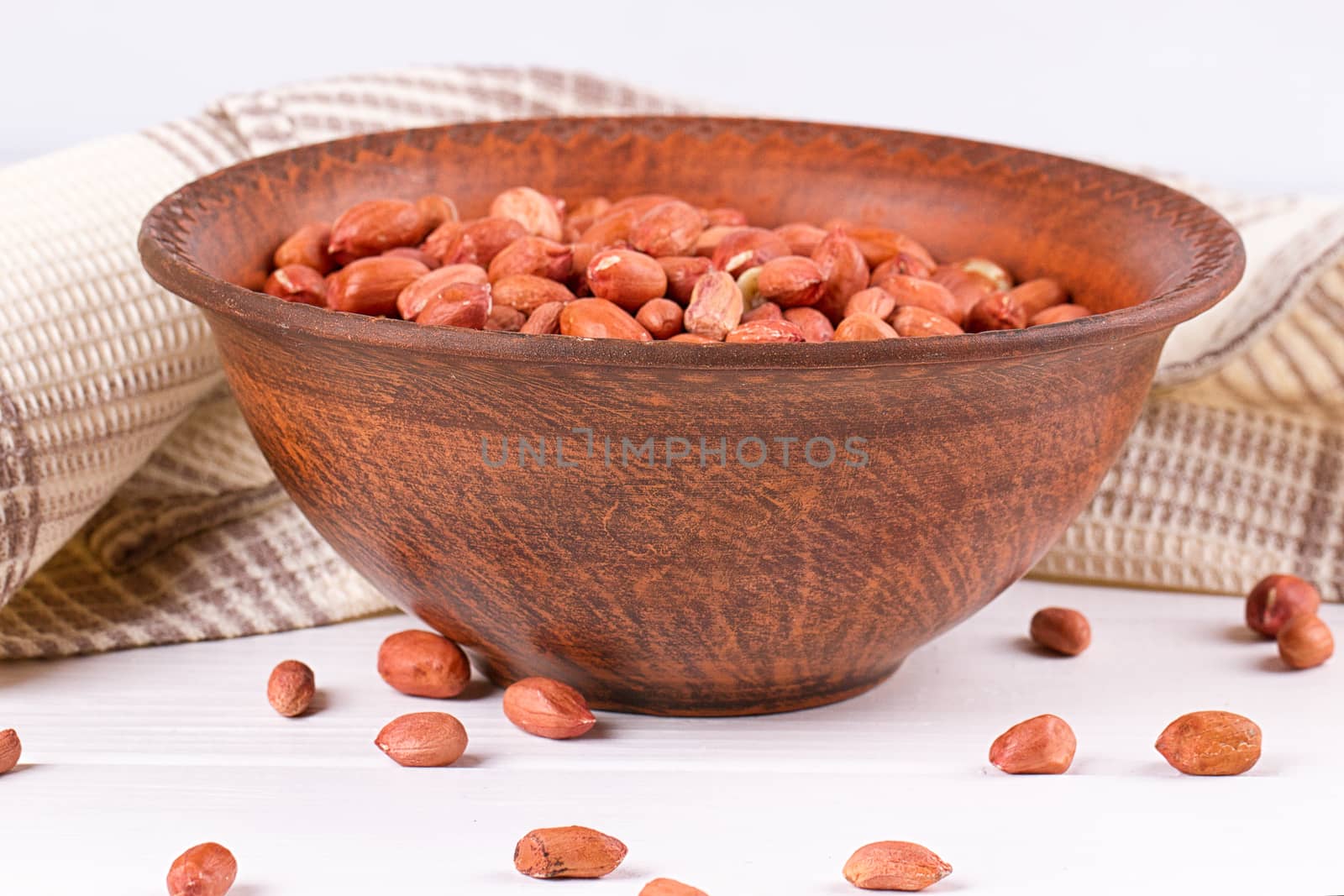 Peanuts in a brown plate. on white background