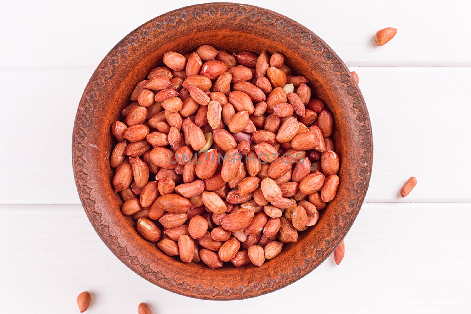 Peanuts in a brown plate. on white background