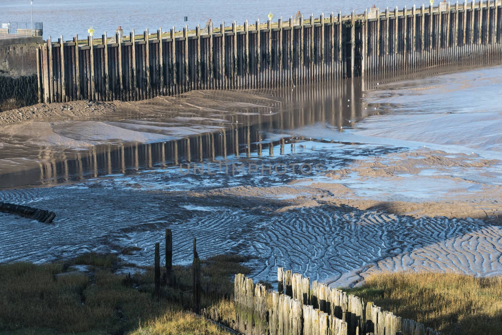 Reflections in the mudflats of a disused jetty