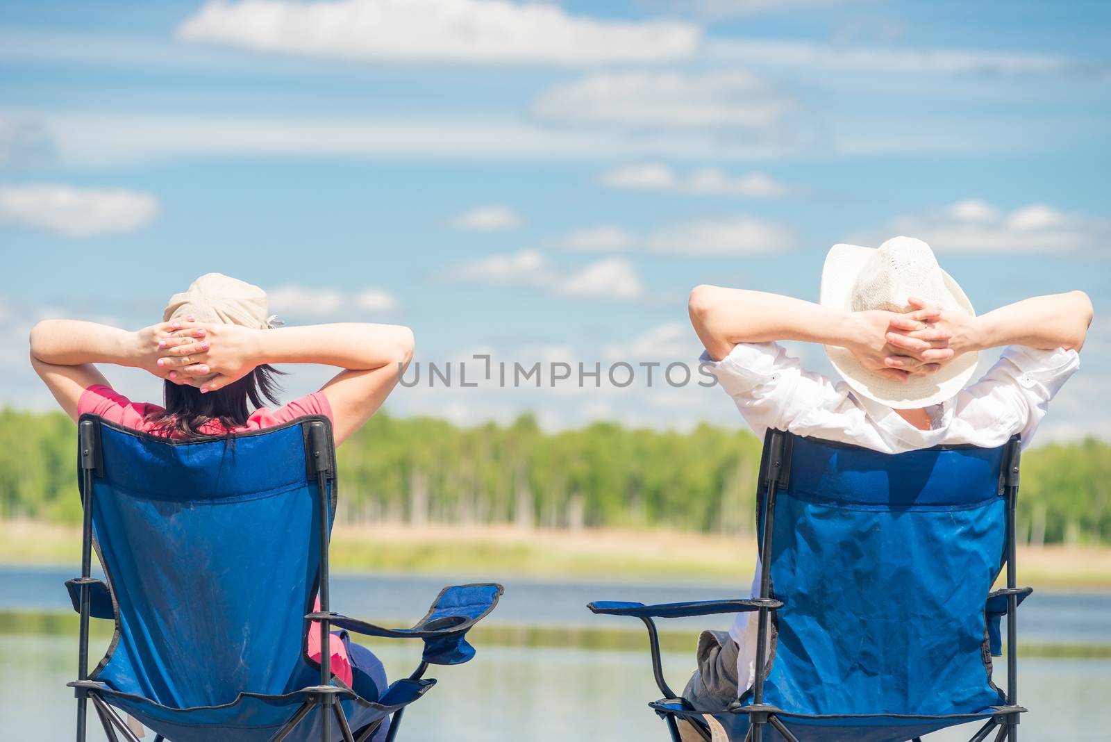 family on chairs resting near a beautiful lake on chairs, view f by kosmsos111