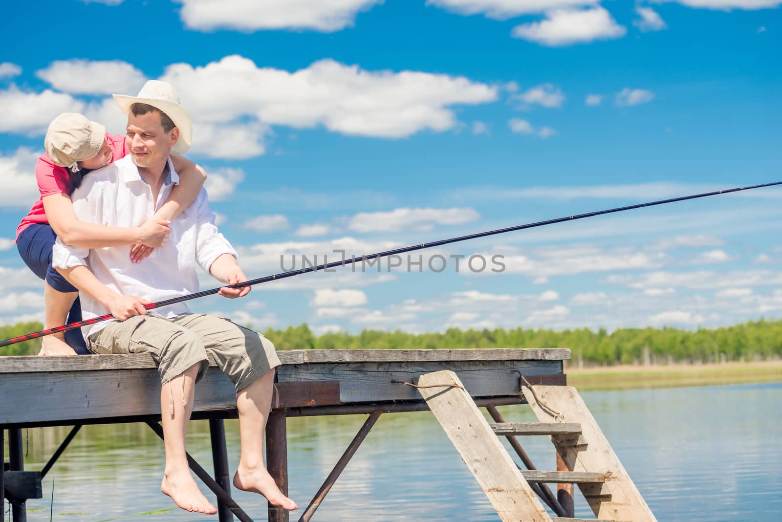 fisherman and his wife on a wooden pier near the lake, a man is fishing