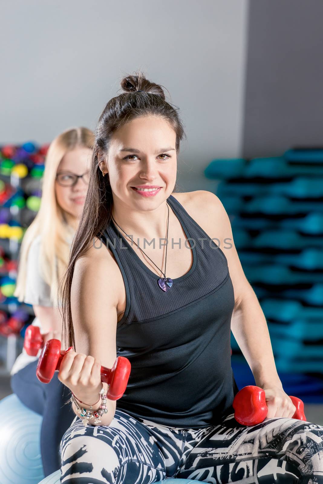 vertical portrait of a cute brunette with red dumbbells during a by kosmsos111