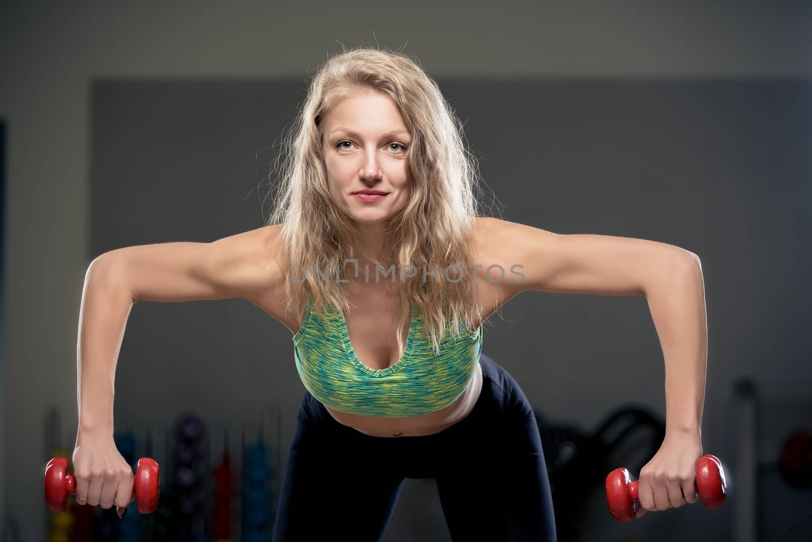 healthy lifestyle, woman exercising with dumbbells in the gym