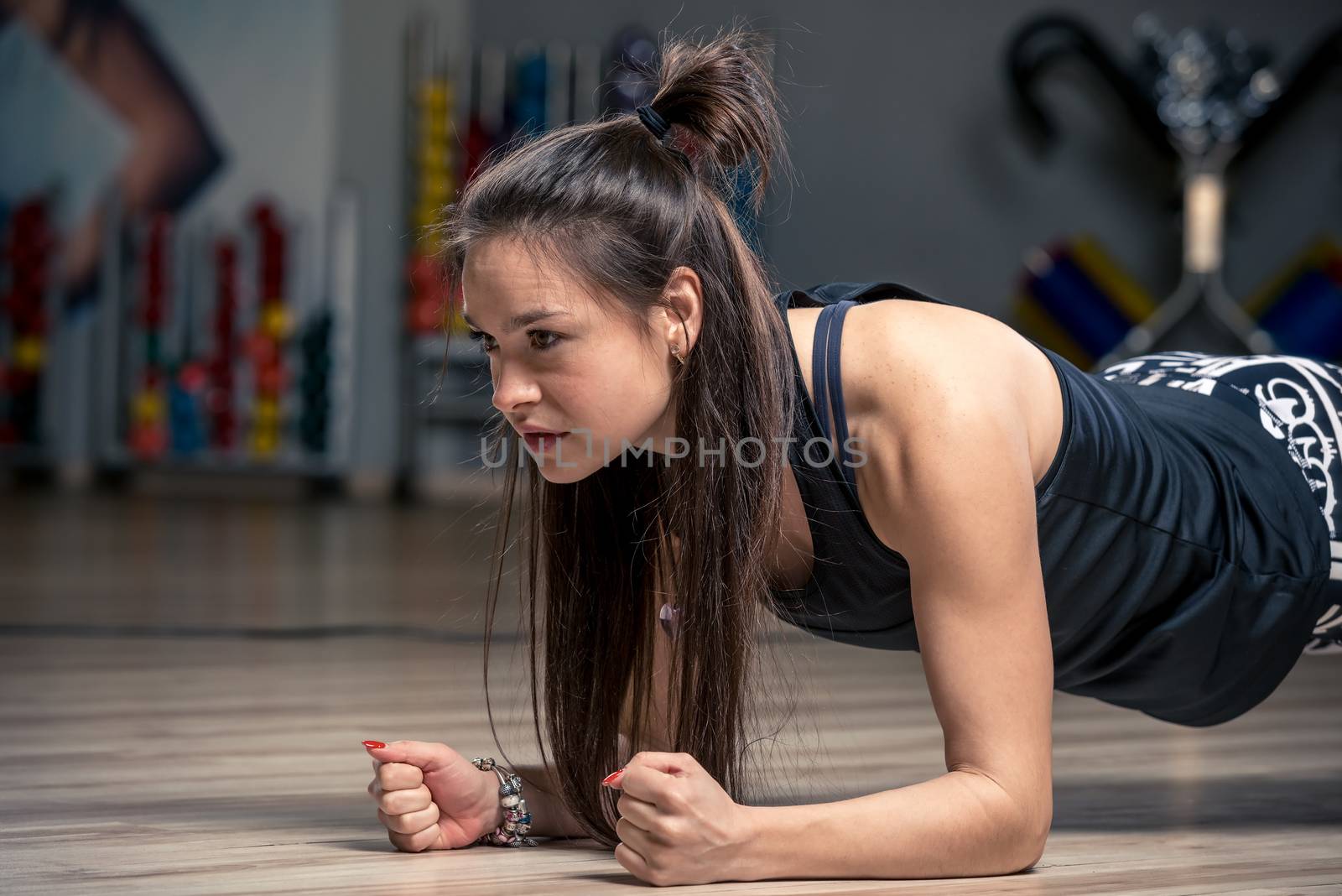 hardy woman performing an exercise strap on the floor in the gym by kosmsos111