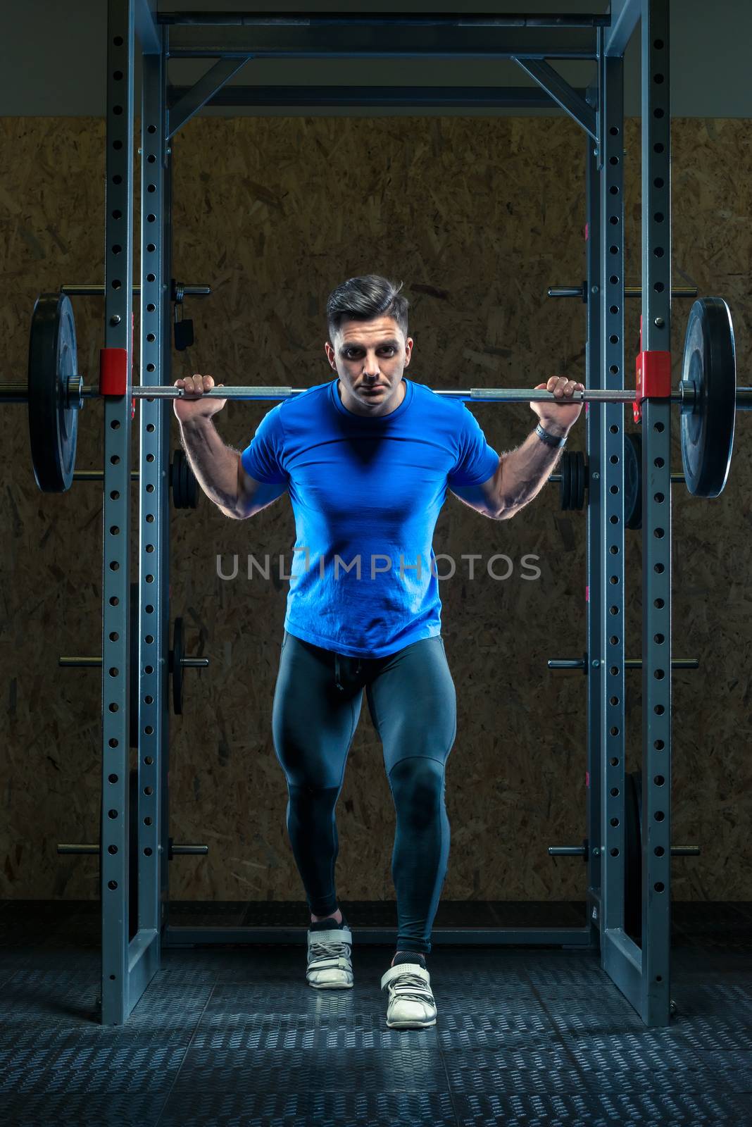 strong athlete in training in the gym with a barbell by kosmsos111