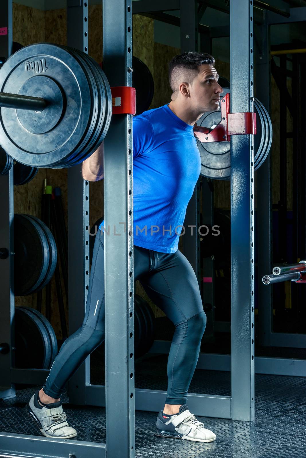 a bodybuilder with a barbell in the gym during a workout by kosmsos111