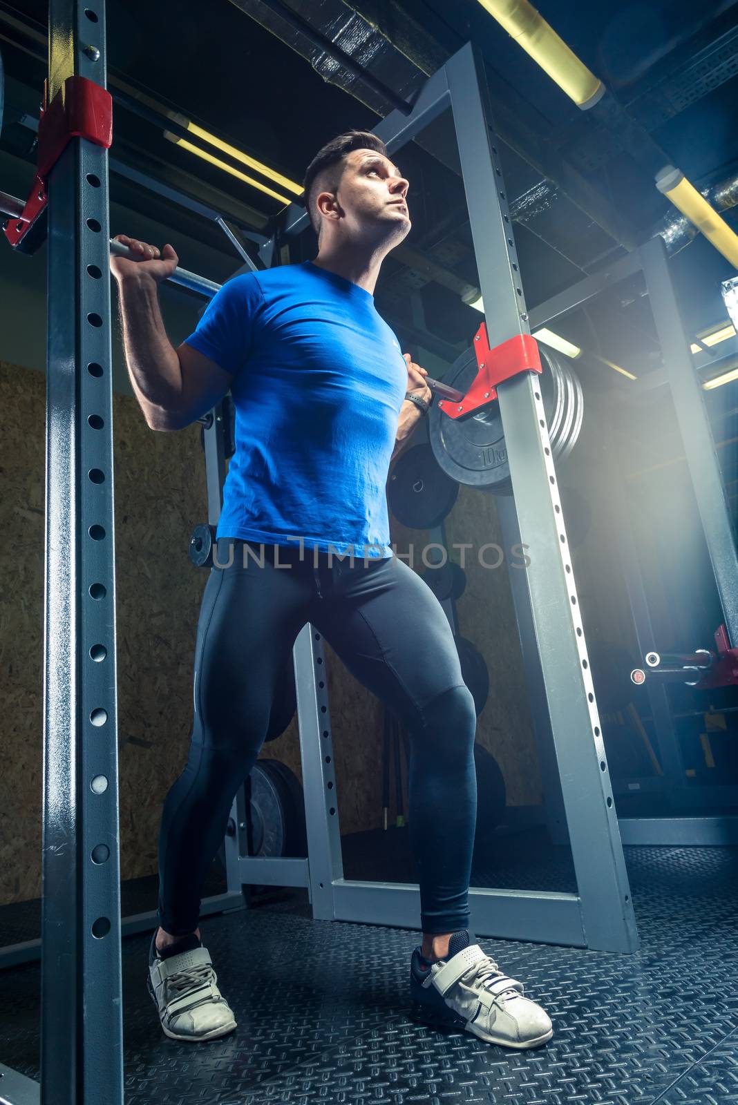 portrait of an athlete in a gym with a heavy barbell