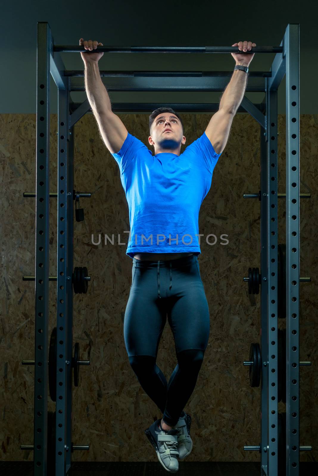 portrait of an athlete in the gym on equipment pulls up