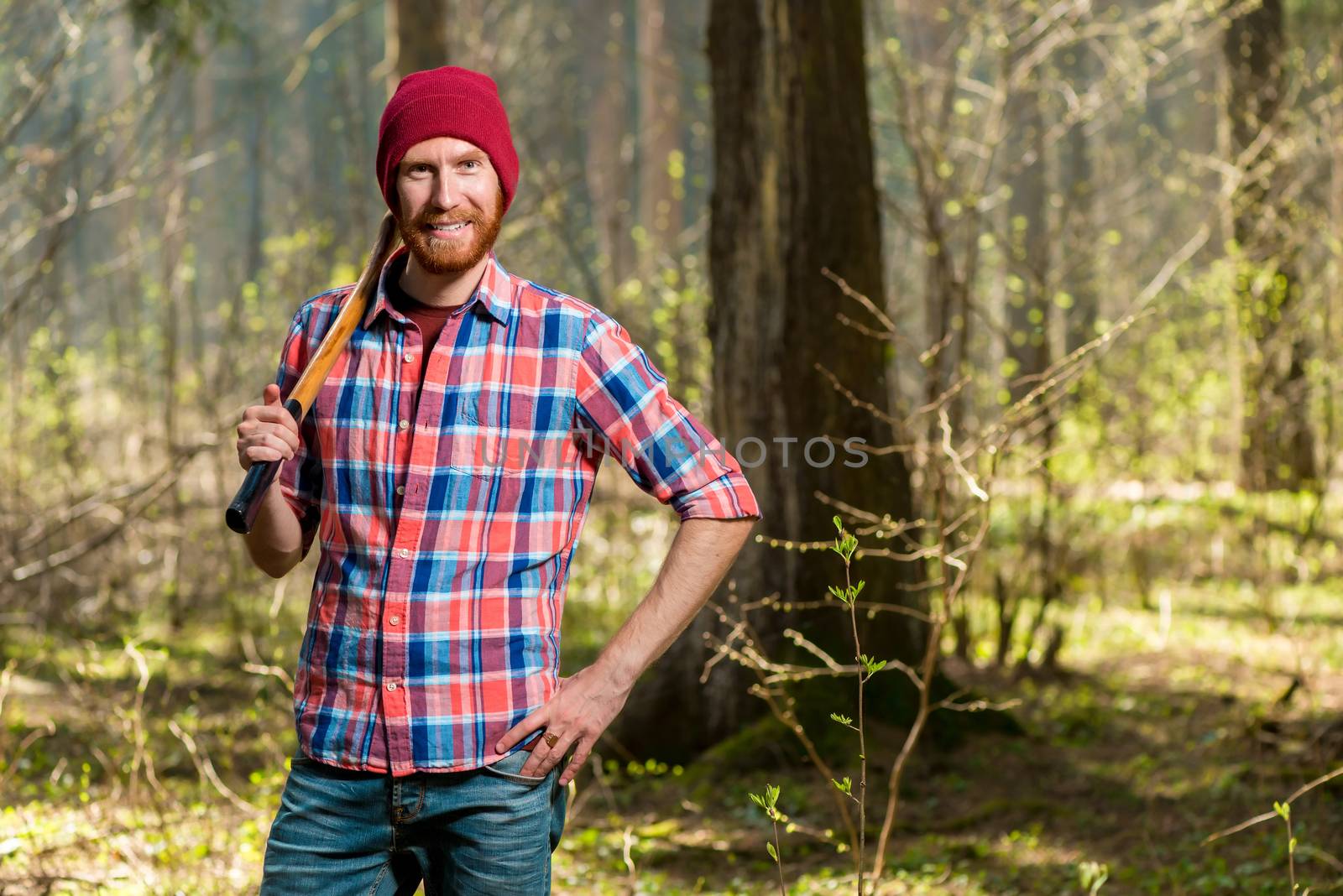 horizontal portrait of a forester with a beard in the forest with an ax
