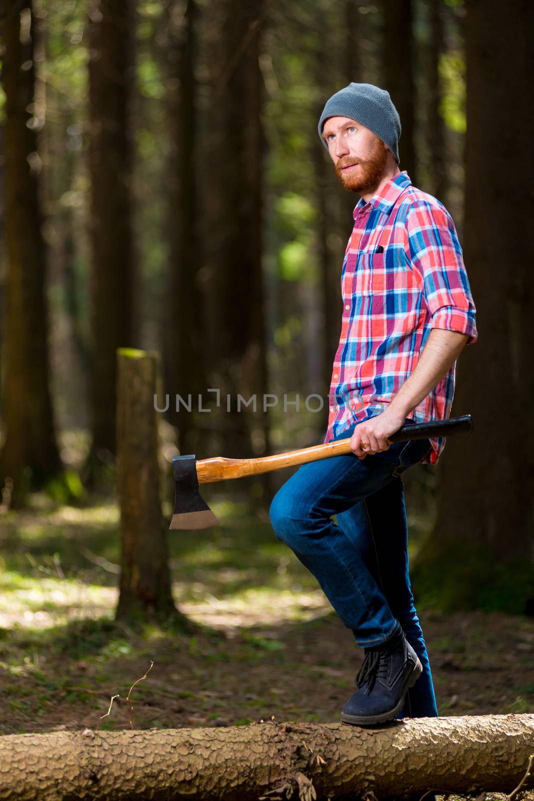 thoughtful forester with an ax near a dumped tree in the forest by kosmsos111