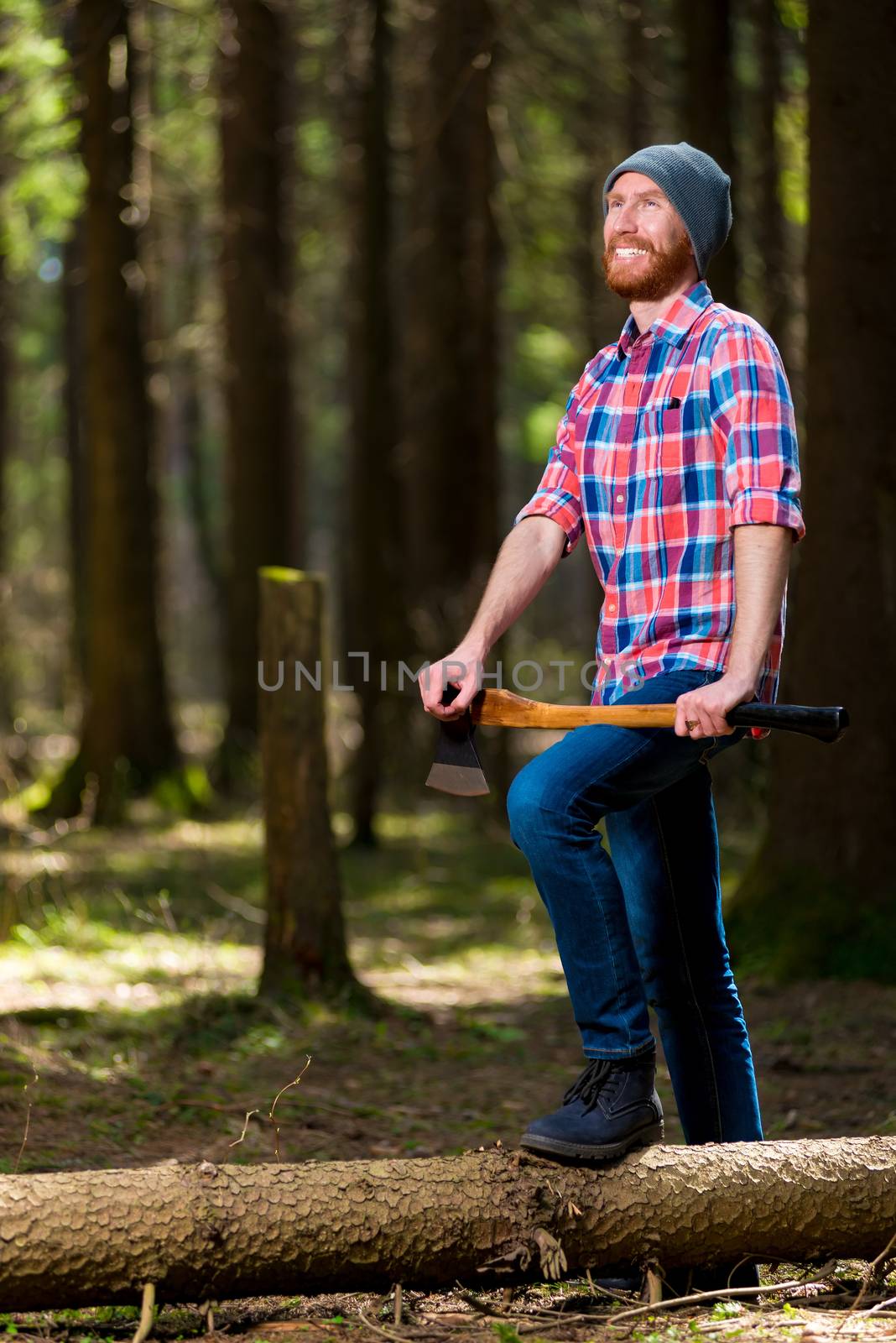 a happy forester with an ax near the dumped tree in the forest s by kosmsos111