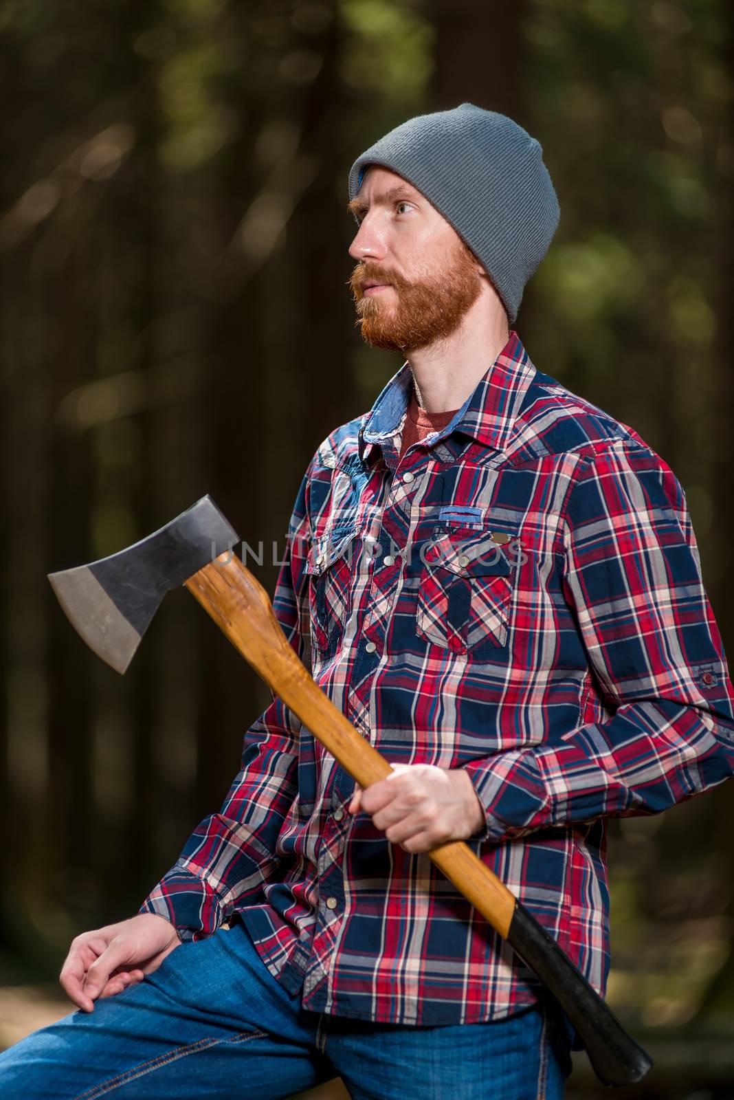 vertical portrait of a lumberjack with an ax in the summer fores by kosmsos111