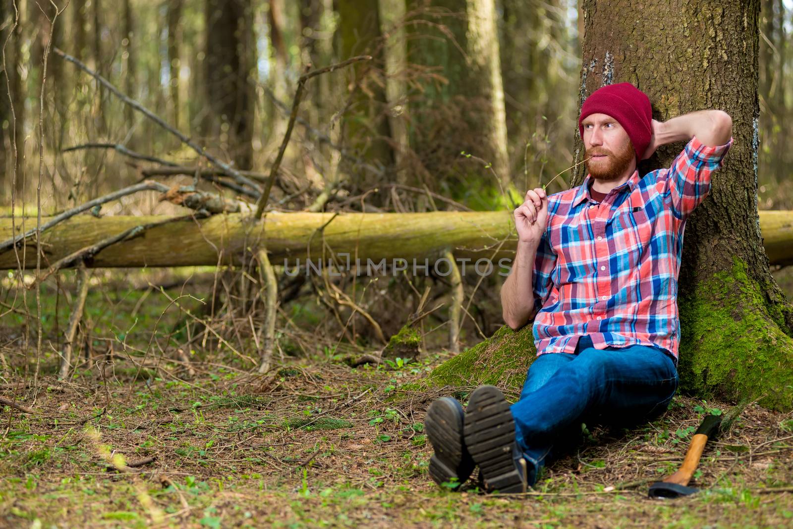 woodcutter after work put off his ax and sat down under a tree to rest in the forest