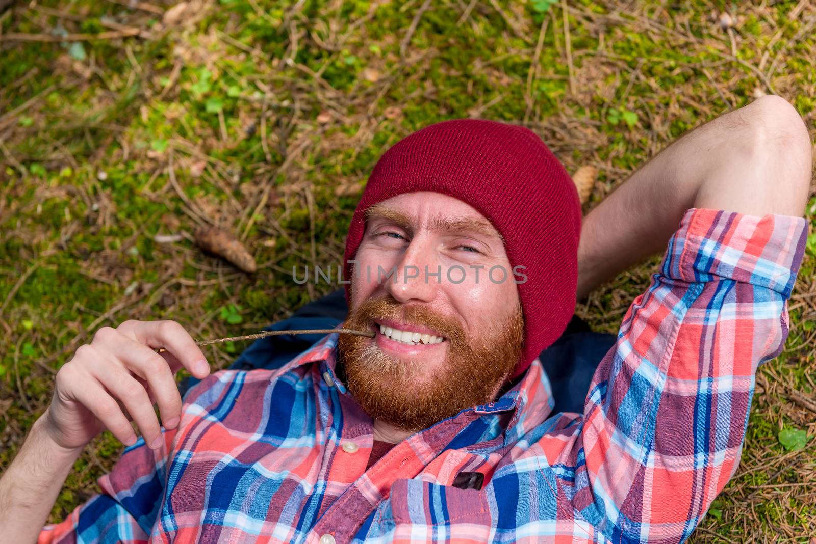 happy forester on vacation in forest, man in hat with beard