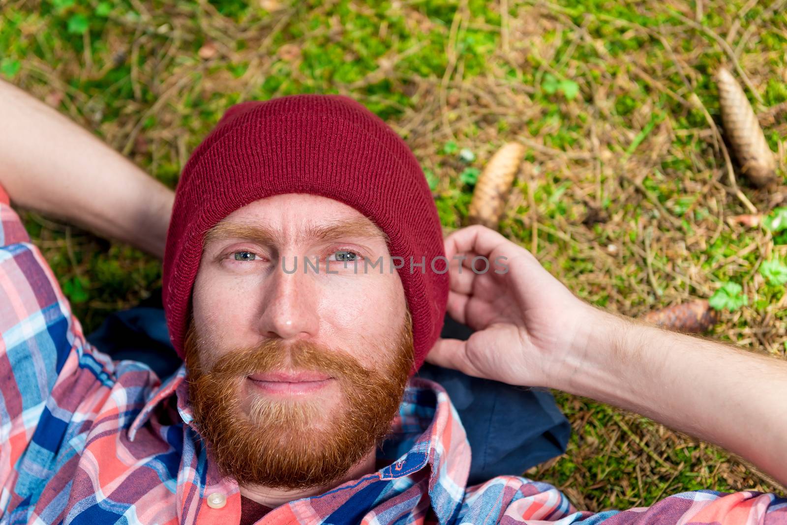 close-up of a male portrait with a red beard against a forest lawn background