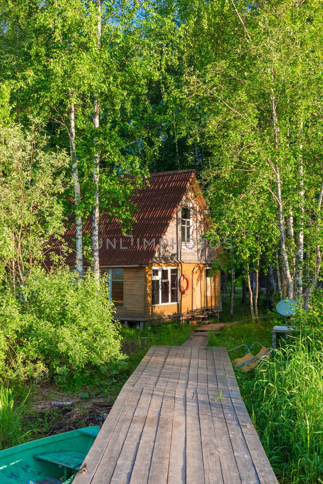 rural wooden fisherman's house on the shore of a lake and a wooden pier