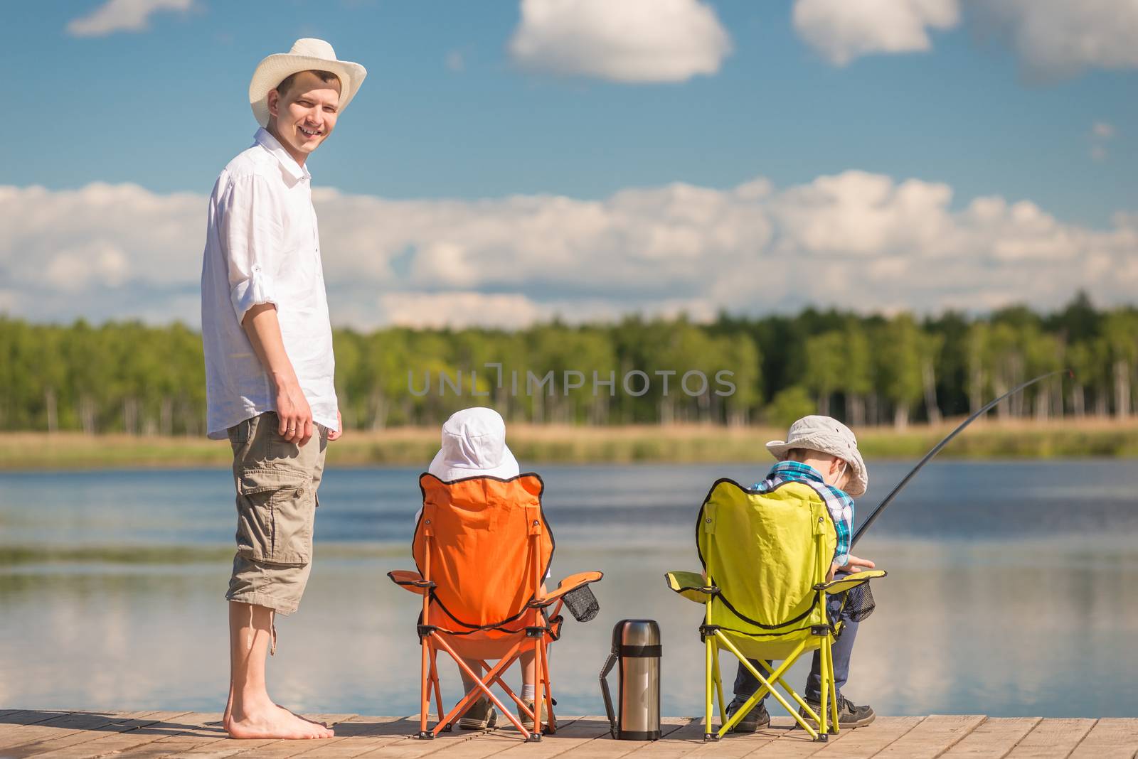 man and two sons on fishing, father teaches children to fish by kosmsos111
