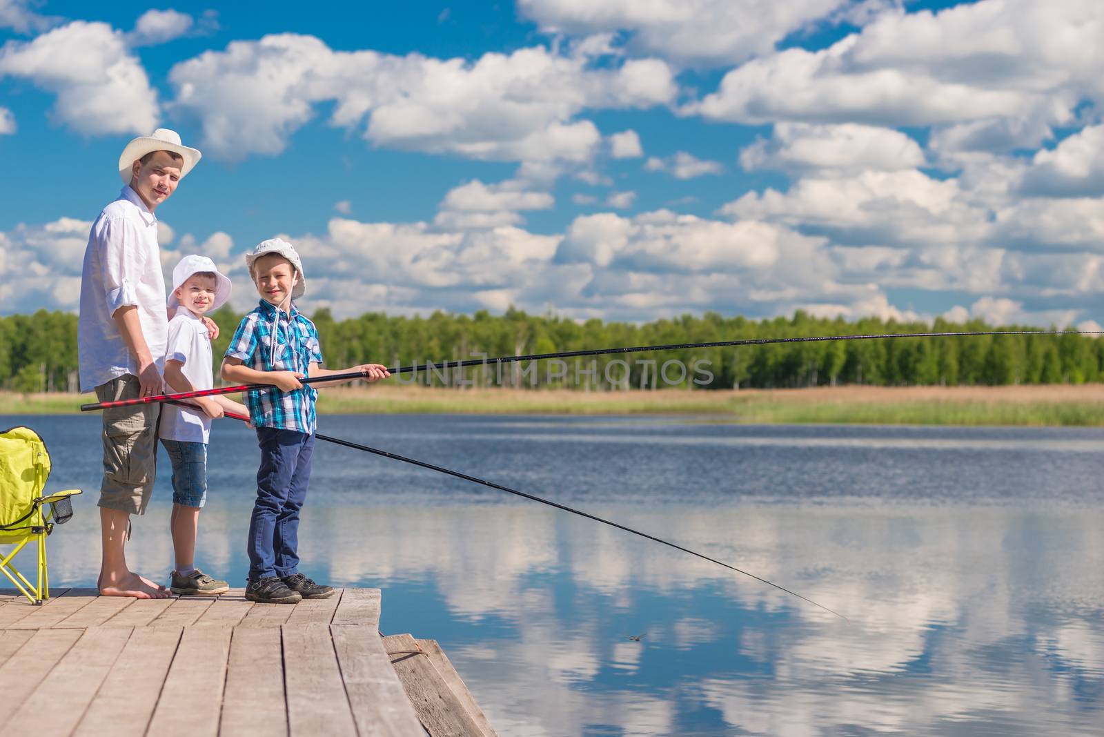The boys and their father spend a day on a fishing trip on a sunny day