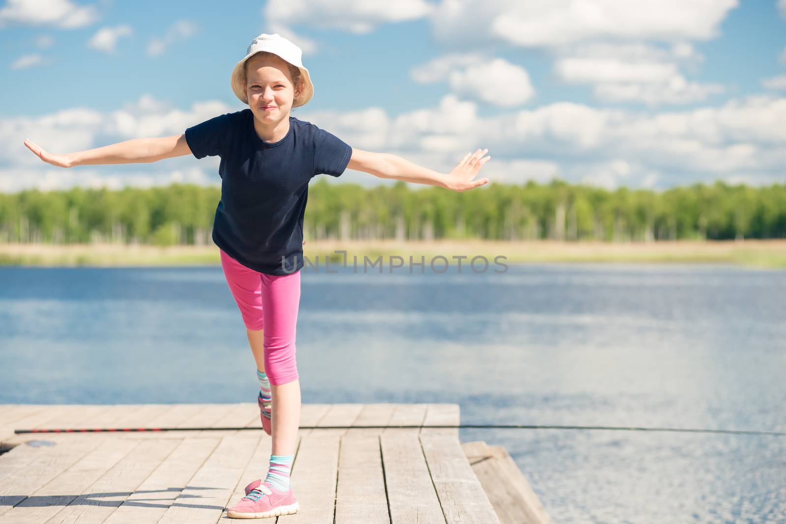 portrait of a girl 10 years old on a pier near a lake