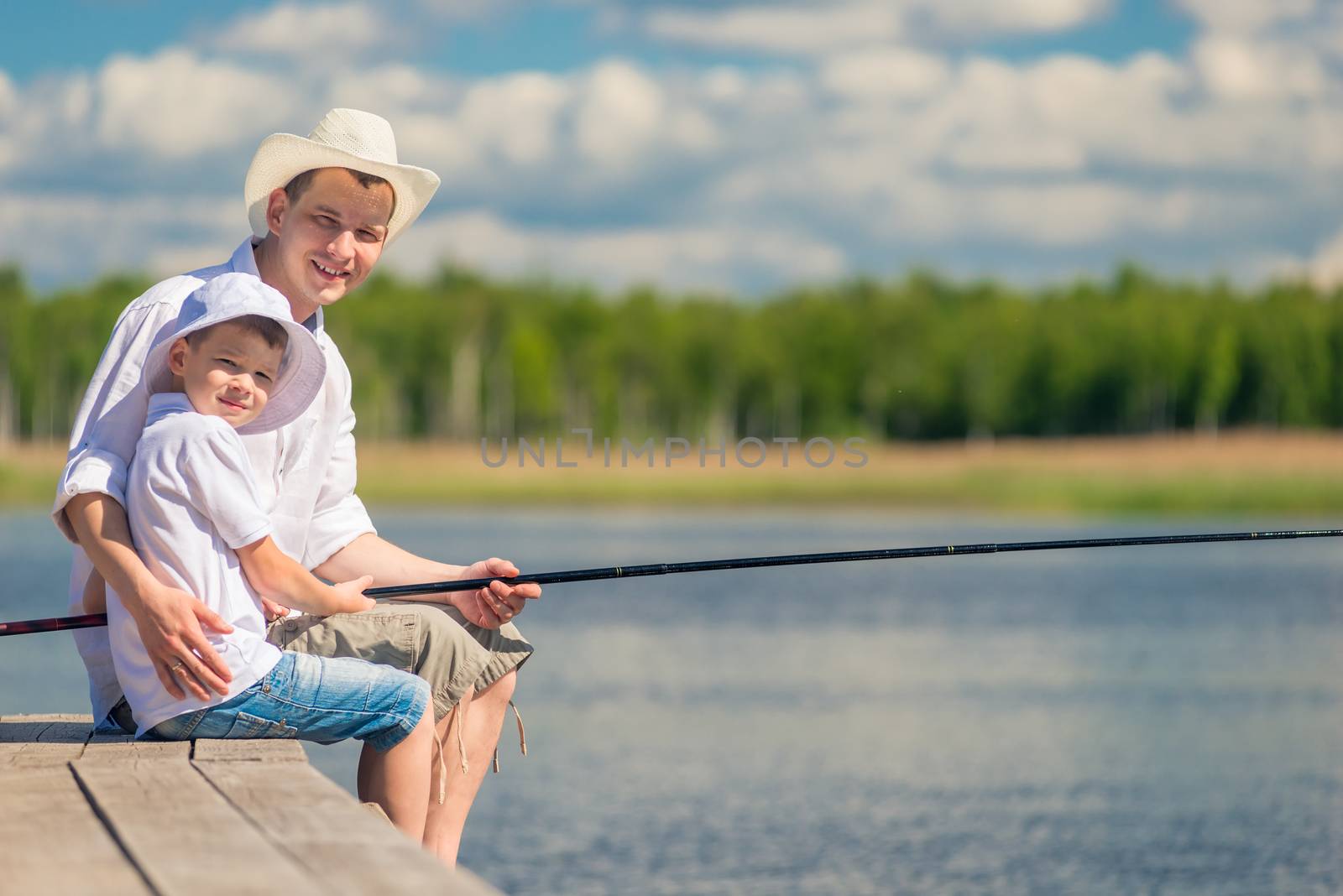 happy men with a fishing rod on a wooden pier while fishing by kosmsos111