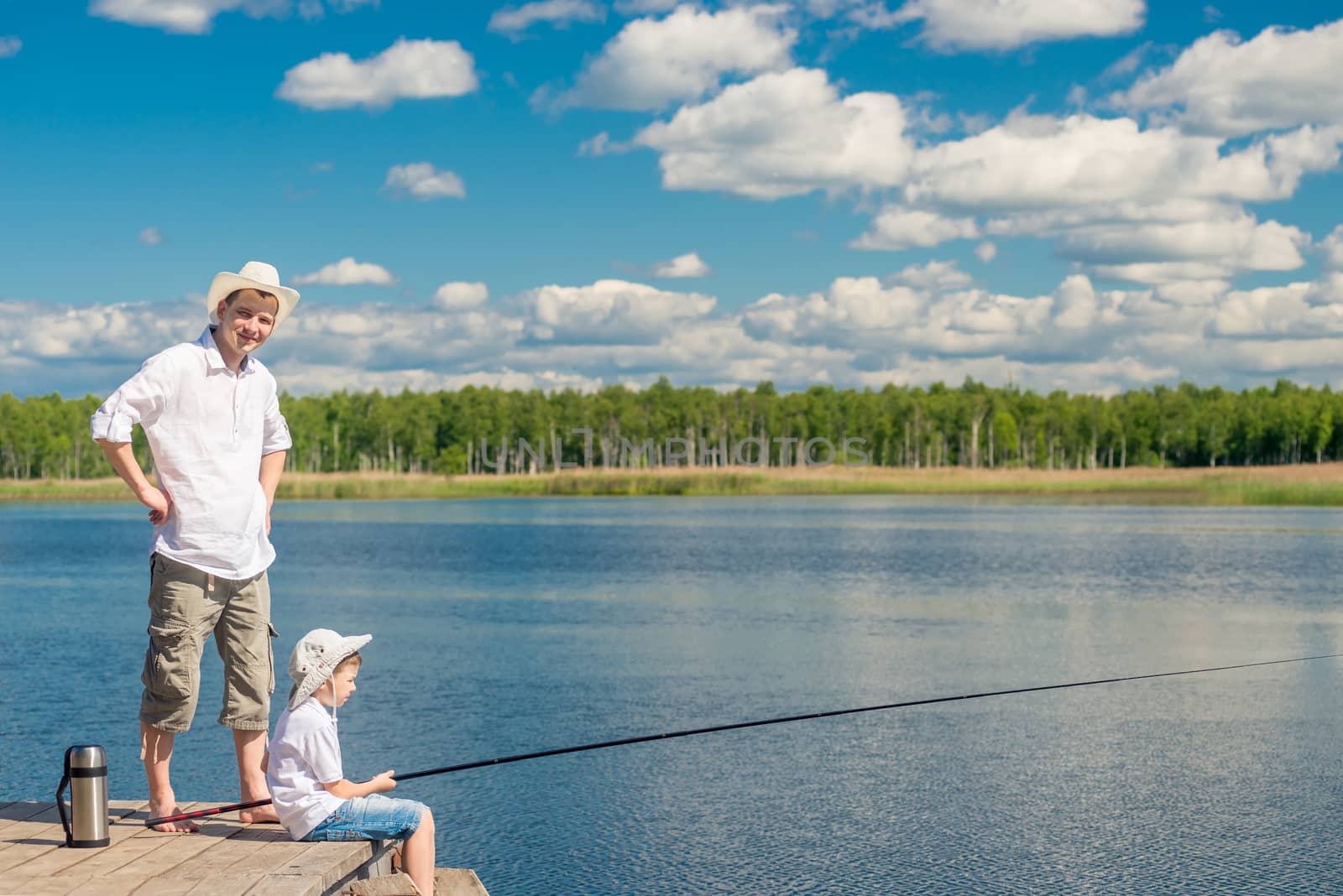 father and son on a wooden pier on a sunny day fishing by kosmsos111