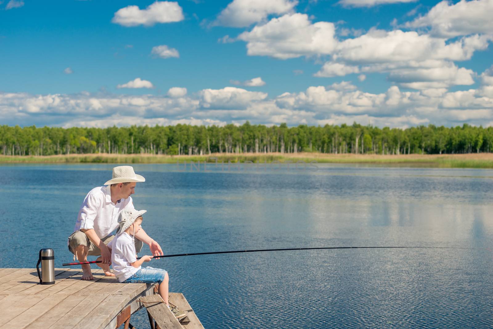 family fishing on a beautiful lake with fishing rods