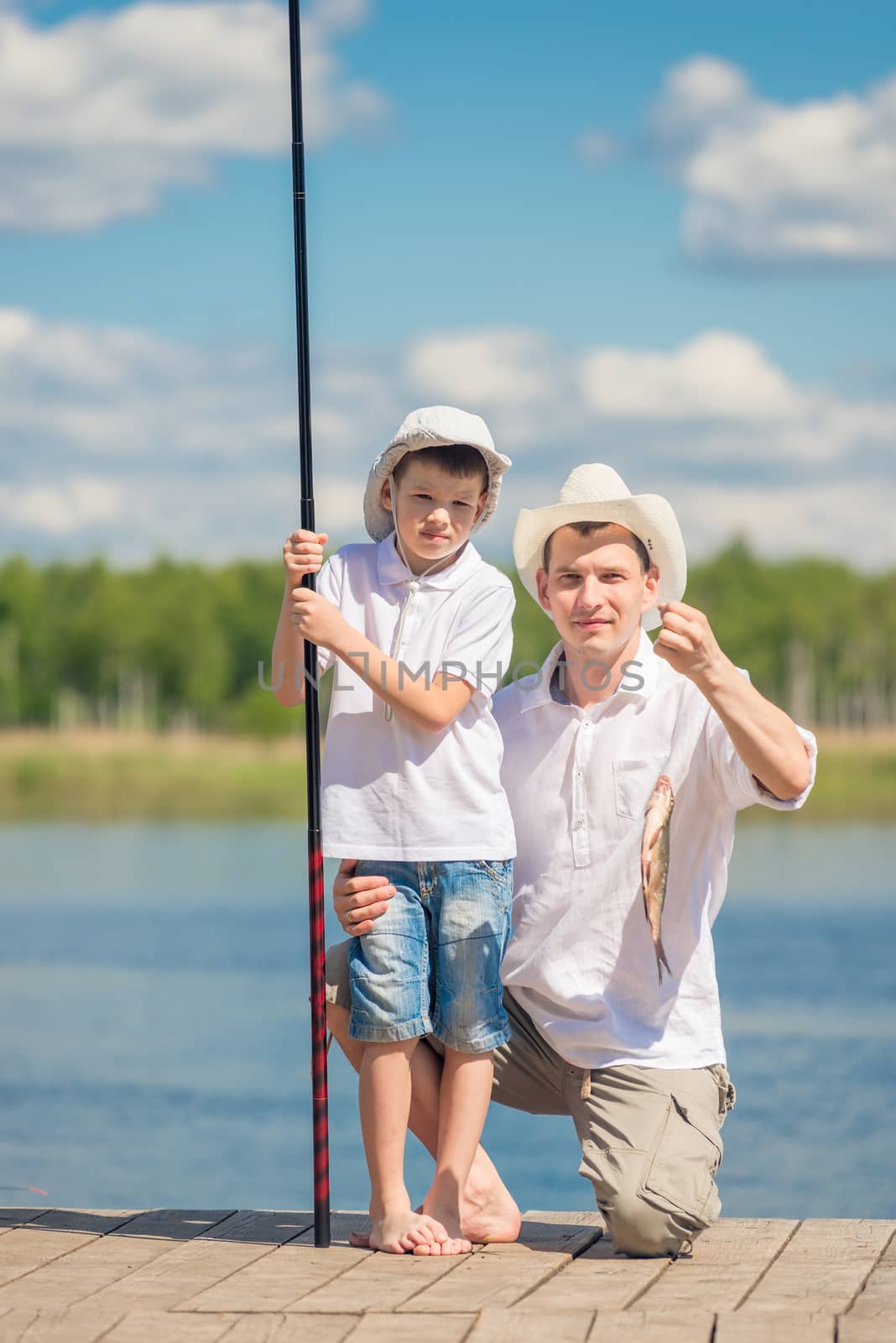 The father shows the fish that his son caught on the bait