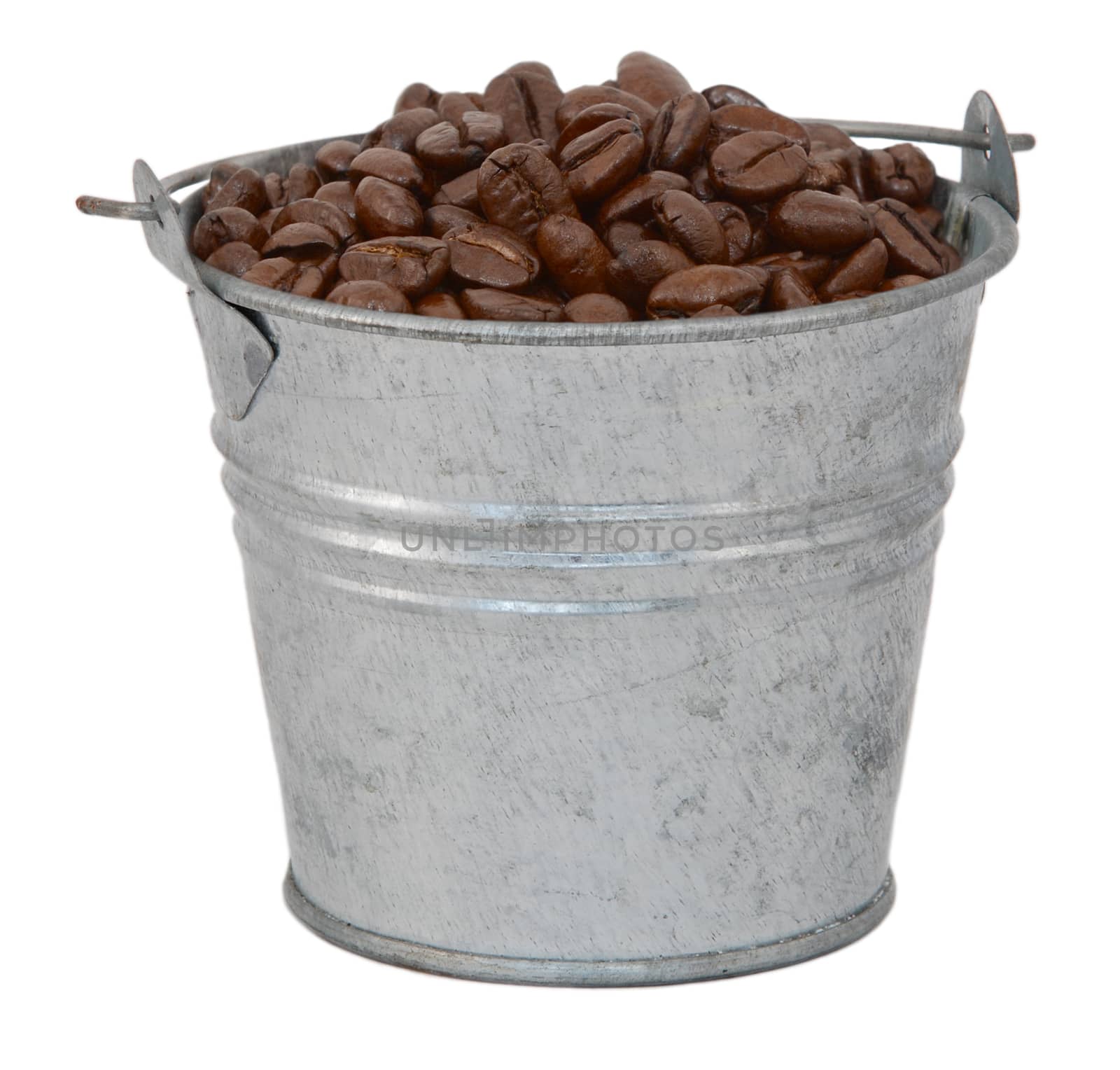 Dark roasted coffee beans in a miniature metal bucket, isolated on a white background