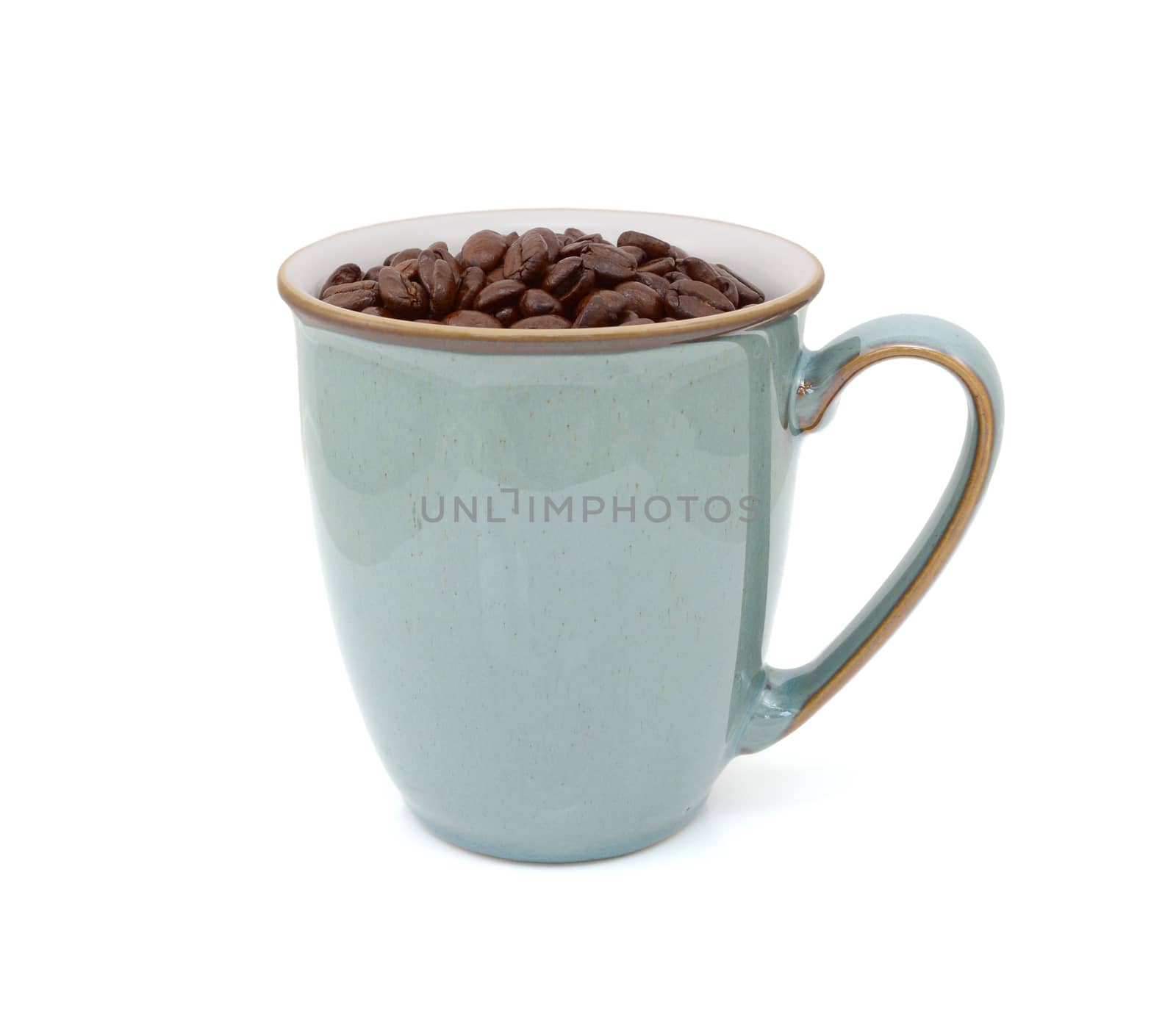 Green mug filled with dark roasted coffee beans, standing on a white background