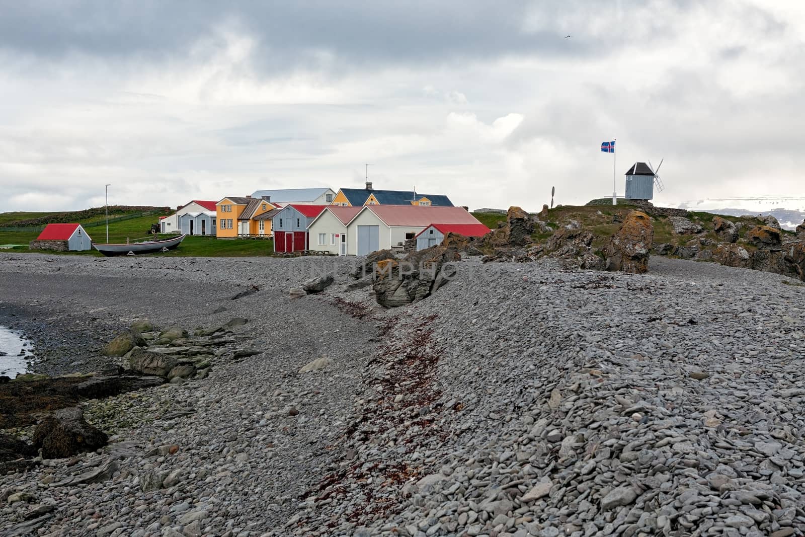Houses and windmill in Vigur island in a windy day, Iceland