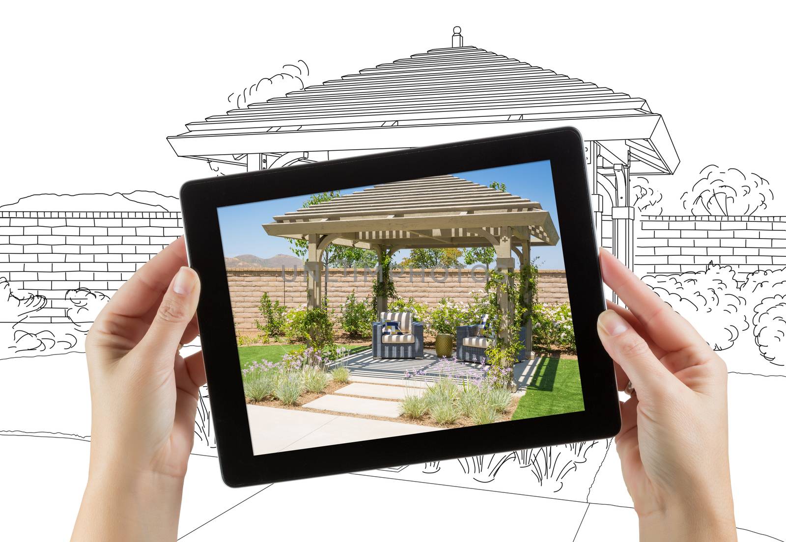 Female Hands Holding Computer Tablet with Photo of Pergola on Screen, Drawing Behind. by Feverpitched